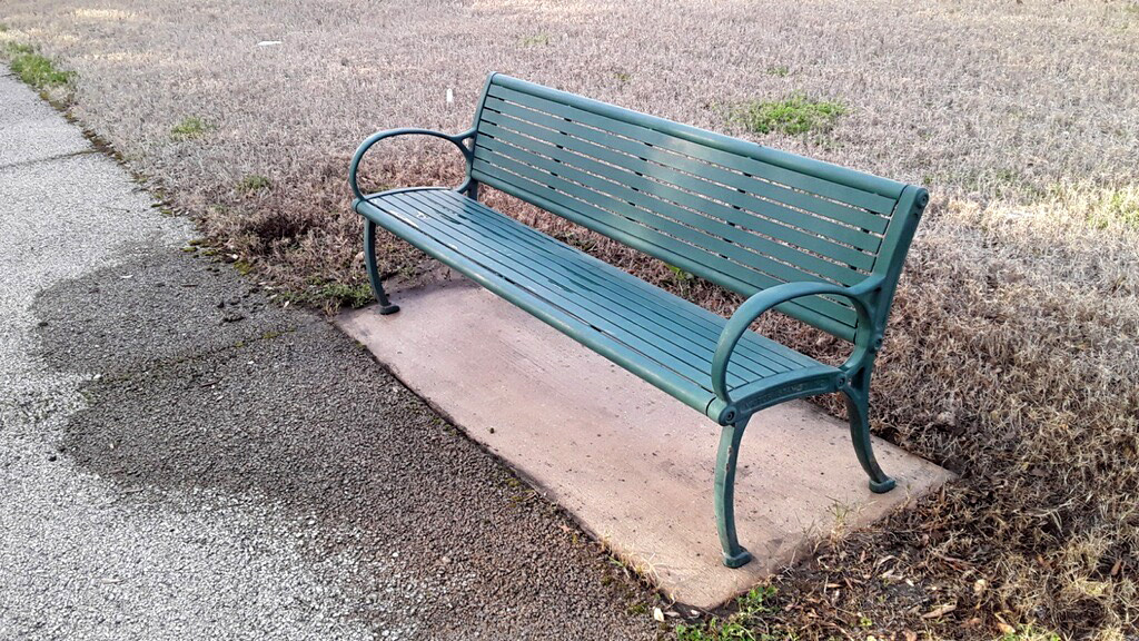 an iron bench in a public park