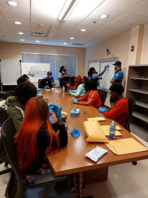 high school students in a workshop with the New Orleans Police Department learning about criminal justice